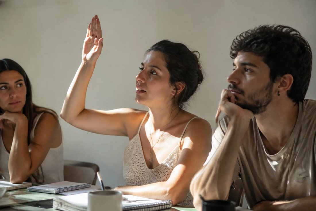 Facilitador em pé apontando para um argumento escrito no quadro durante a sessão