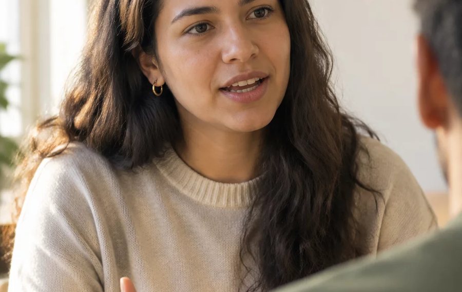 Duas pessoas frente a frente na mesa: uma sustenta a fala, a outra anota o que ouviu